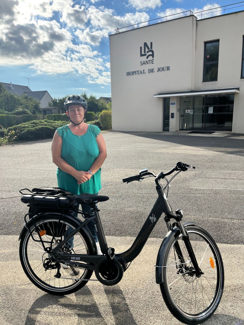 Sophie, salariée de LNA Santé, avec son vélo de fonction électrique